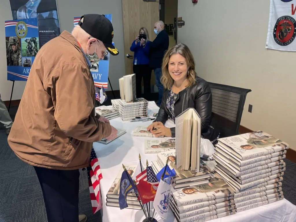 Shannon Huffman Polson signing The Grit Factor for a veteran at a corporate speaking event